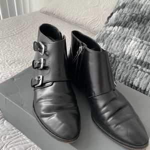 Black Michael Kors booties with metal detailing.